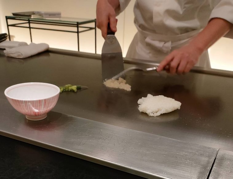 白米が鉄板へ。ニンニクが刻まれる瞬間。